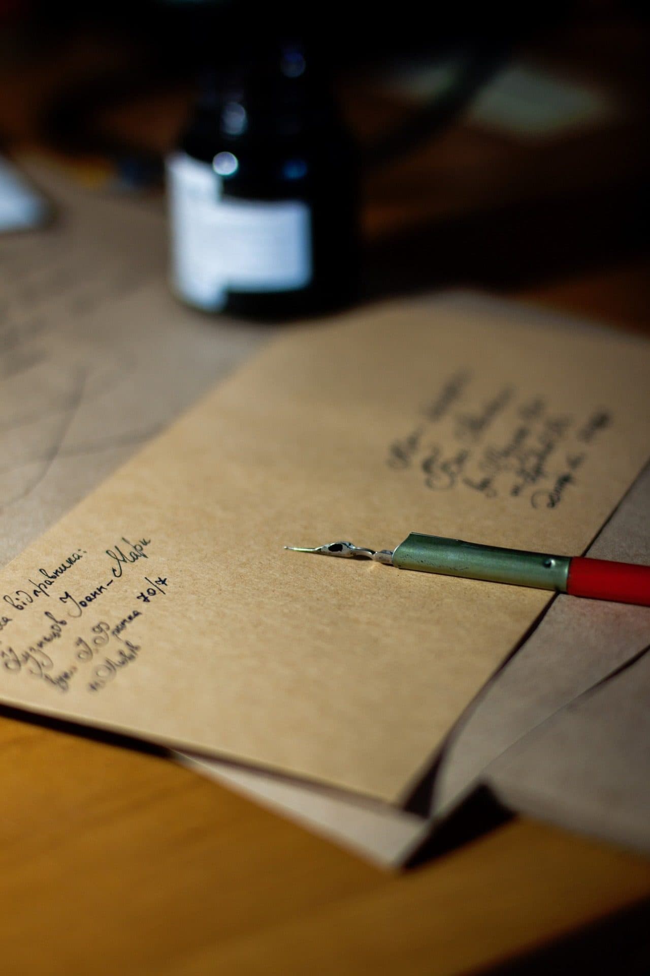 A fountain pen resting on a hand-addressed kraft envelope