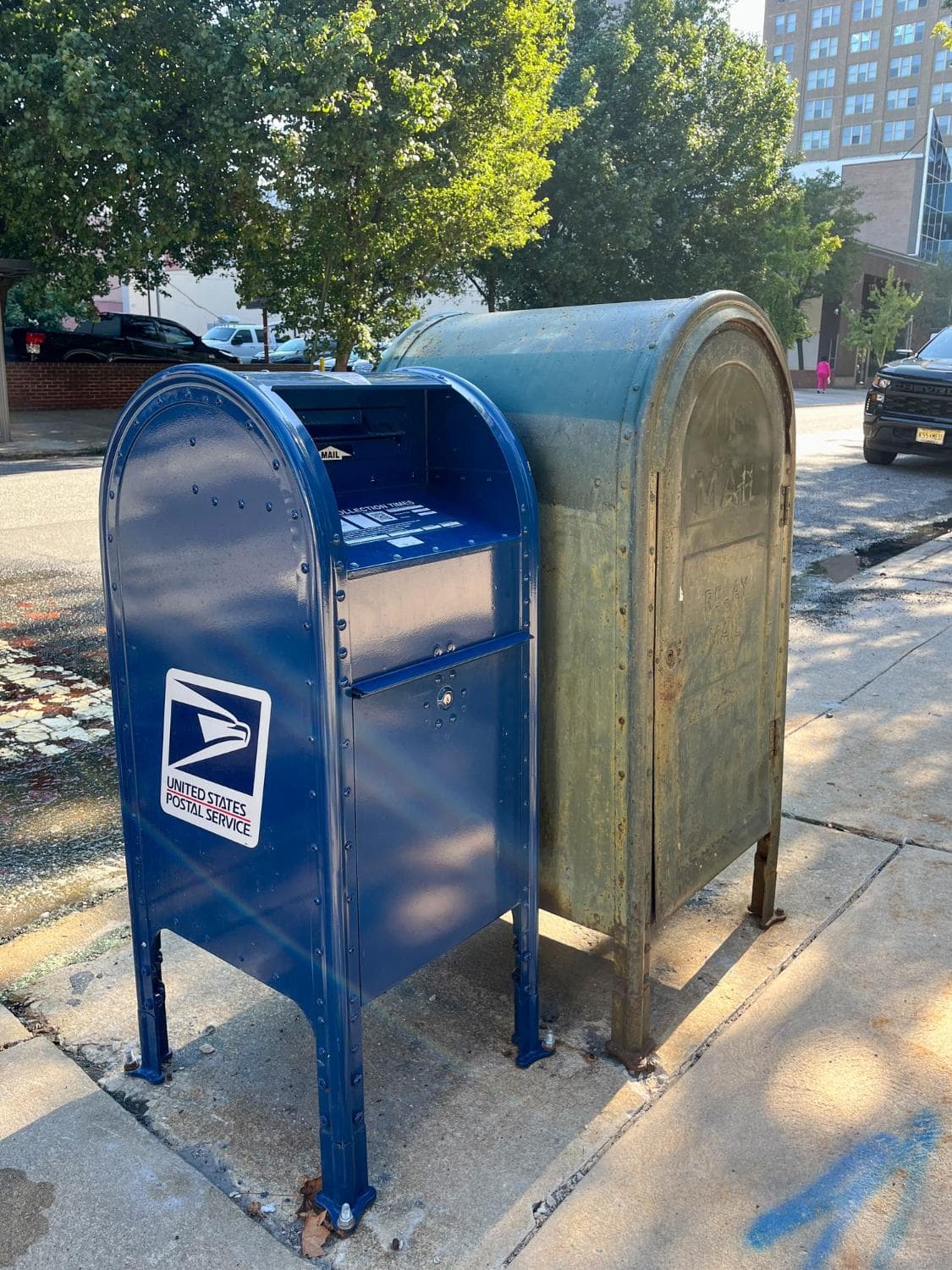 Blue USPS collection mailboxes on a city street