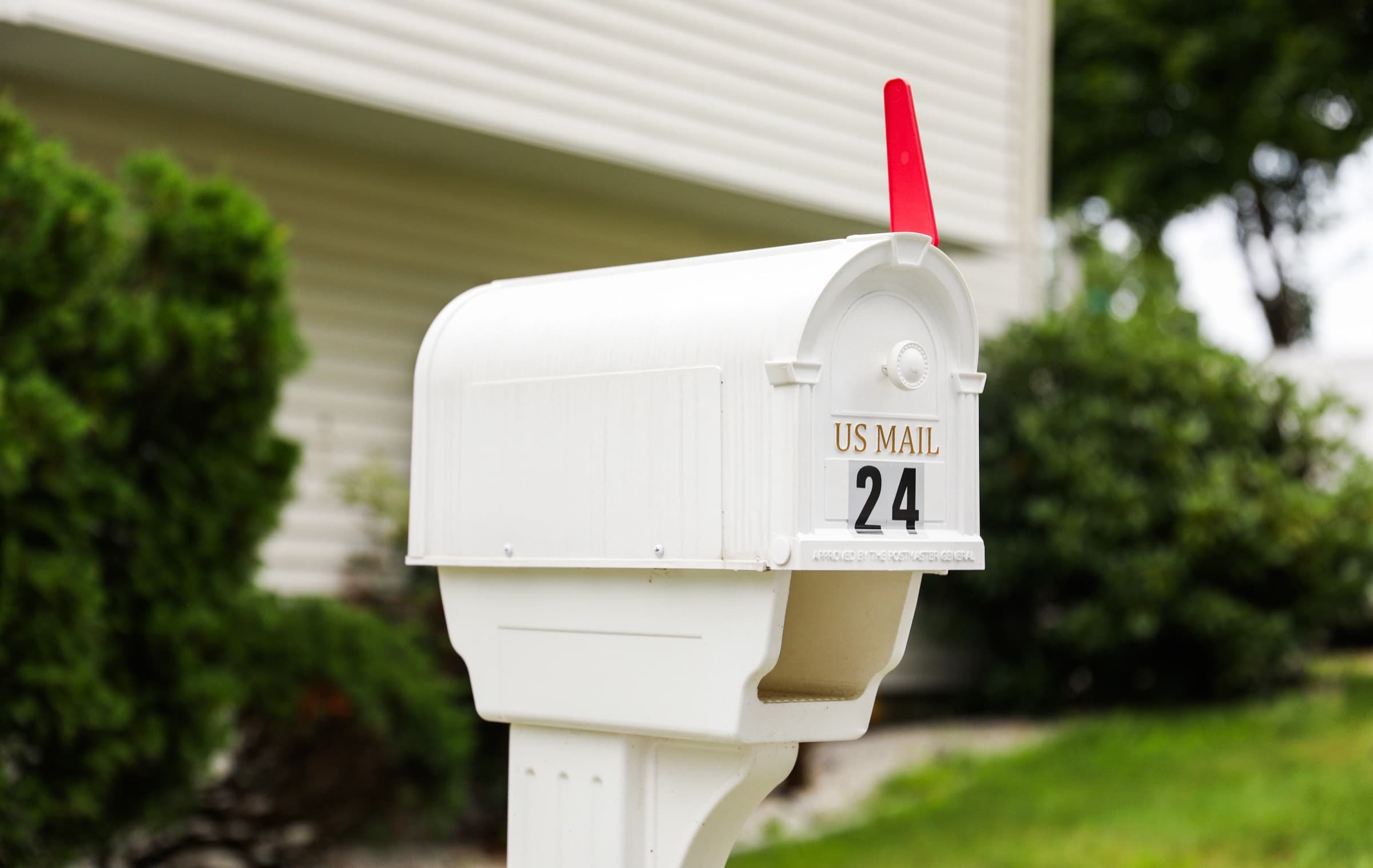 A white residential mailbox with the flag raised
